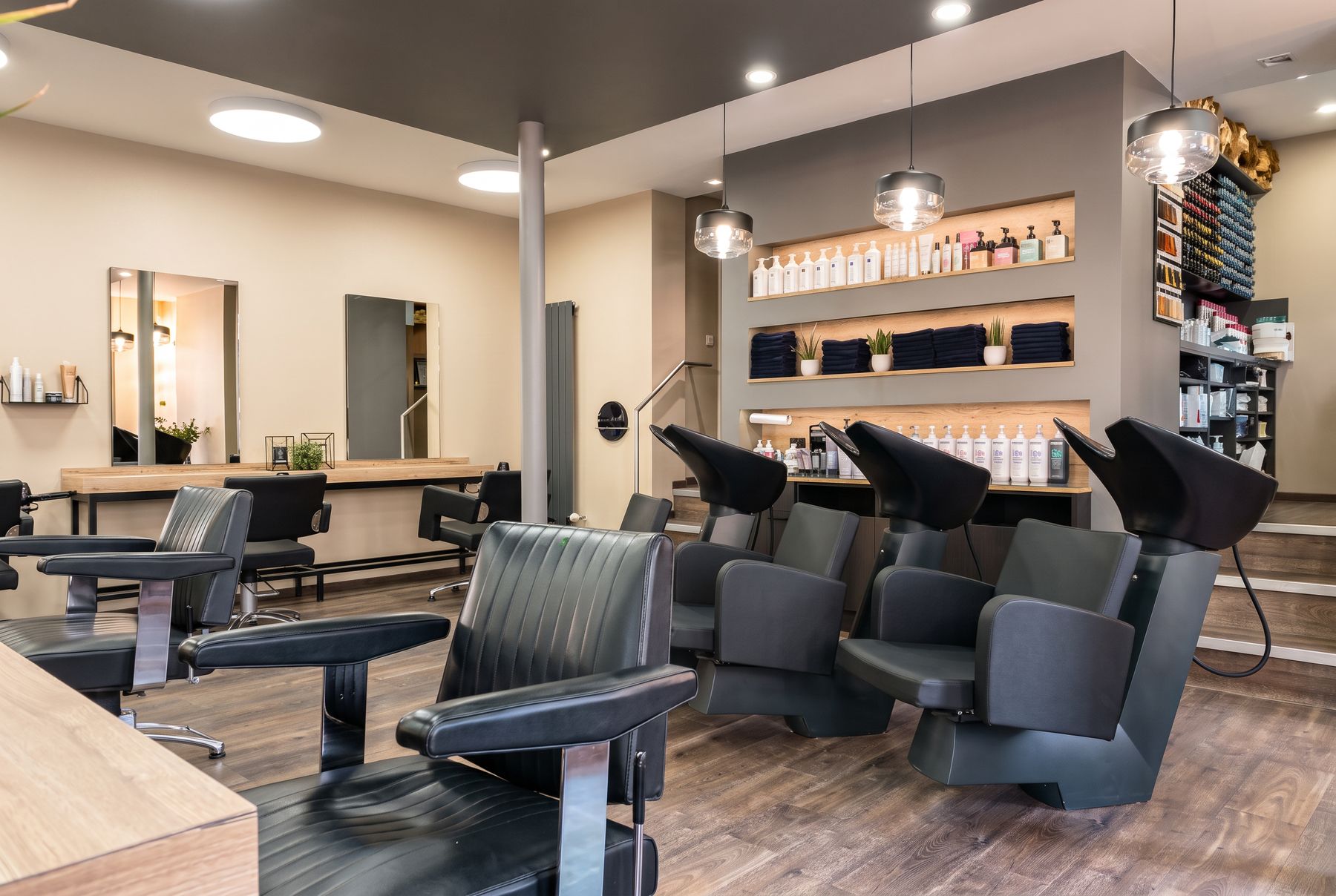 Salon mit dunklem Holzboden und schwarzen Bedienplätzen