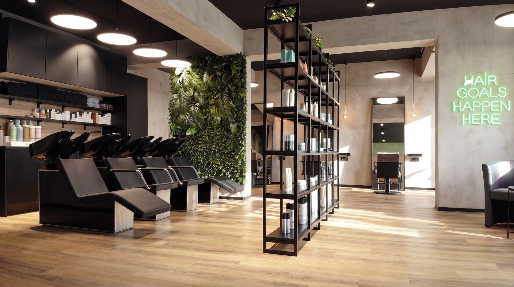 Salon mit Pflanzenwand, Waschplätzen und Leuchtschrift